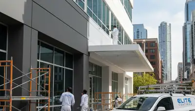 Commercial painting crew finishing office exterior in Baltimore, MD with durable weather-resistant coatings