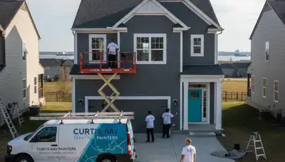 Professional house painters working on exterior home in Baltimore, MD